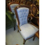 Two late Victorian walnut nursing chairs raised on turned front supports,