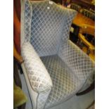 Edwardian upholstered wing armchair on square tapering supports covered in a blue fabric