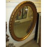 Oval gilt framed bevelled edge wall mirror together with an ebonised piano stool with revolving