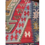 Kurdish Kelim rug with a lobed medallion design in shades of red, green and blue,