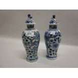 Near pair of 19th Century Chinese blue and white baluster form vases with covers decorated with