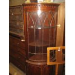 Reproduction mahogany bow fronted corner cabinet with a single glazed door above a pair of panel