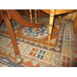 Kazak style rug with a twin hooked medallion design in shades of burnt orange, blue and ivory,