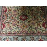 Small Turkish rug with floral design on a beige ground with turquoise border