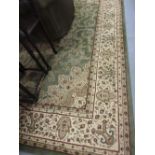 Machine woven Persian design carpet with medallion and floral design on a green ground,