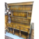 Good quality reproduction oak dresser with a boarded shelf back above three drawers,