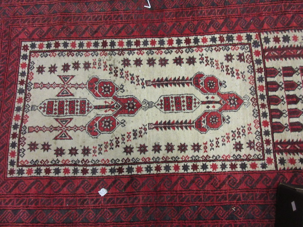 Belouch prayer rug with a stylised design on an ivory ground with multiple red ground borders