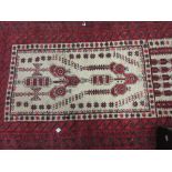 Belouch prayer rug with a stylised design on an ivory ground with multiple red ground borders