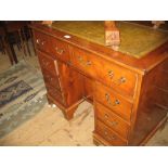 Reproduction yew wood kneehole desk with a leather inset top