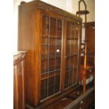 Mid 20th Century oak two door display cabinet with leaded glass doors enclosing shelves on baluster