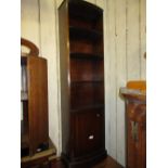 Narrow reproduction mahogany bow fronted bookcase with open shelves above a panelled door