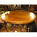 Victorian oval walnut marquetry inlaid tilt top table on four turned column base with carved