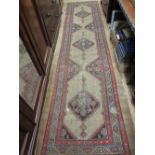 Kurdish rug with triple repeating medallion design on a beige ground with borders,