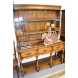 Good quality reproduction oak dresser with a boarded shelf back above three drawers,