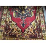 Mid 20th Century Anatolian rug with a large medallion design on a red ground with corner designs