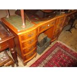 Reproduction yew wood twin pedestal desk with a three section leather inset top above nine drawers