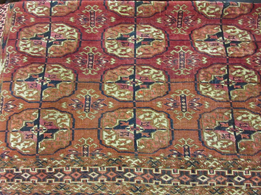 Small Tekke rug with three rows of six gols on a wine ground with borders,