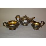 William IV silver three piece tea service of circular squat floral embossed design,