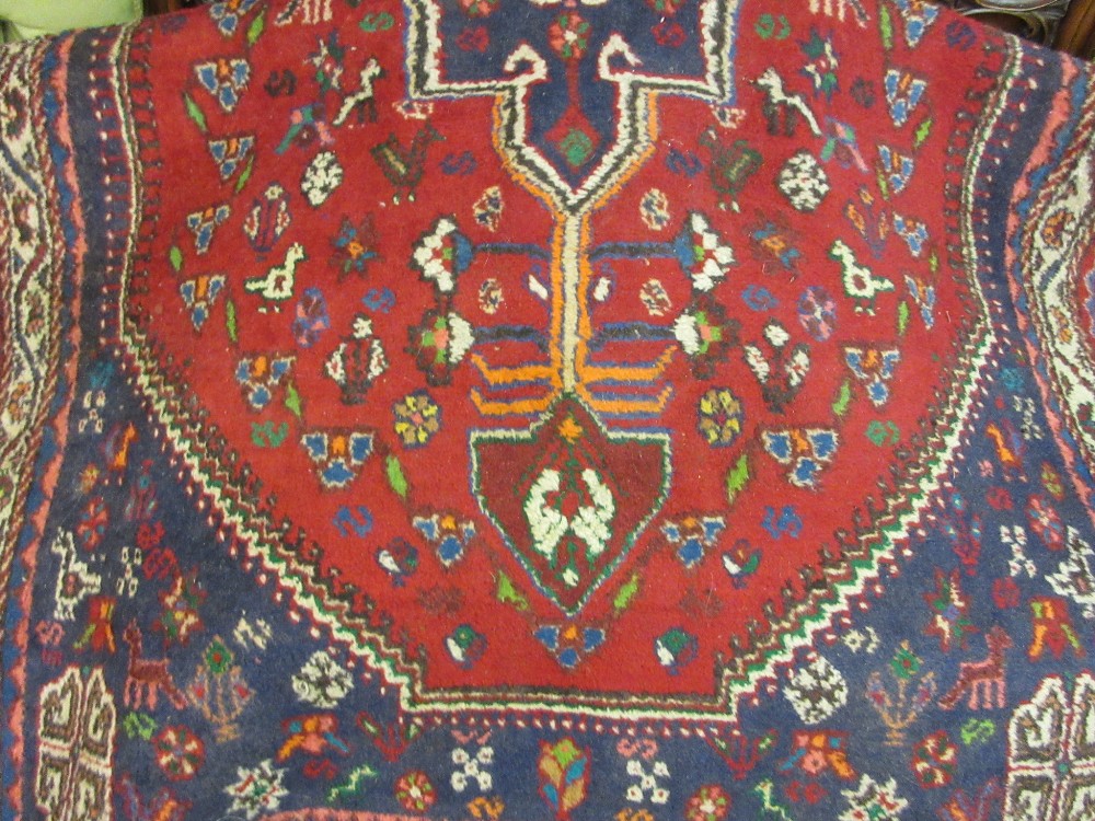 Indo Persian rug with lobed medallion and all-over stylised floral and animal designs on a red