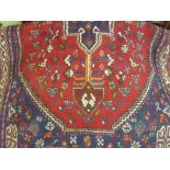 Indo Persian rug with lobed medallion and all-over stylised floral and animal designs on a red