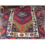 Belouch rug with triple hooked medallion design in shades of wine red, blue and green,