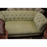 Late Victorian button upholstered Chesterfield sofa on low turned supports with brass casters