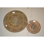 Two circular Eastern copper wall plates with white metal mounts