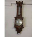 Negretti and Zambra aneroid barometer / thermometer in ornate carved oak case with silvered dials