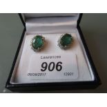 Pair of 18ct white gold oval emerald and diamond cluster ear studs, the emeralds approximately 6.