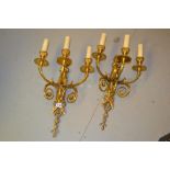 Pair of good quality gilt brass three light wall sconces of figural and scroll design