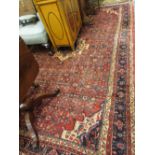 Late 20th Century Senneh style carpet with a medallion and all-over Herati design on a red ground