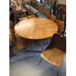 20th Century circular teak dining table raised on four shaped laminated supports together with a