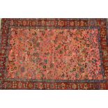 Saruq rug with an all-over stylised floral and bird design on a pink ground with crimson repeating