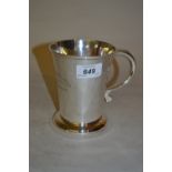 Plain silver mug of tapering form with scroll handle,