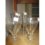 Set of six Lalique champagne flutes with decorative stems and a group of five Edwardian wine