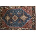 Small South West Persian rug with a triple hooked medallion design on a blue ground with borders,