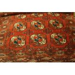 Small Turkoman rug with three rows of gols on a red ground with borders,