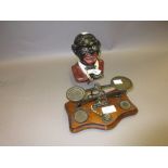 Cast iron figural money bank together with a pair of mahogany based postal scales with weights