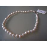 Single row uniform cultured pearl necklace with silver barrel clasp