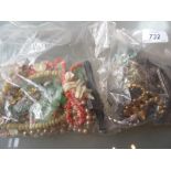 Two bags containing a quantity of various costume jewellery including brooches,