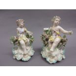Pair of 19th Century Continental porcelain candlesticks in the form of seated cherubs (a/f and