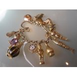 9ct Gold charm bracelet with various good quality charms including: diamond chip set pig,