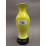 Chinese small yellow ground baluster form vase on a circular hardwood base,