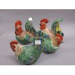 Two pairs of Chinese porcelain figures of cockerels and hens, decorated in red, green, blue etc.