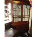 Late George III mahogany standing corner cabinet with a moulded cornice above a pair of bar glazed