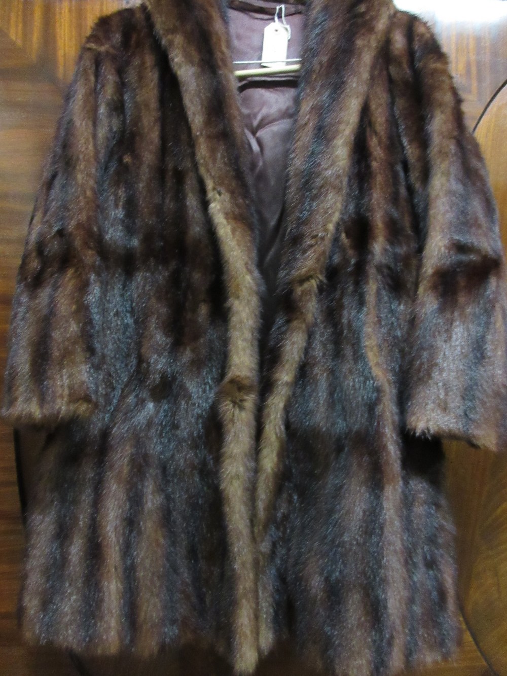 Ladies dark brown fur jacket together with a ladies black astrakan fur jacket