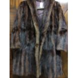 Ladies dark brown fur jacket together with a ladies black astrakan fur jacket