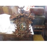 Black Forest cuckoo clock having carved decoration and surmounted with a stag's head (one antler