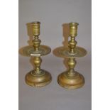 Pair of turned brass circular candlesticks with drip trays