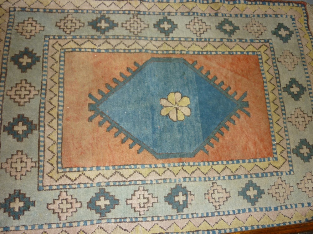 20th Century Turkish rug with a single medallion design on an ivory ground with blue border,
